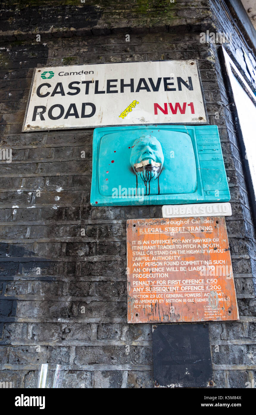 Debajo del nombre de la calle para firmar Castlehaven Road en la ciudad de Camden, Londres, es una pequeña pieza de arte de la calle y un aviso legal acerca de la venta ambulante ilegal Foto de stock