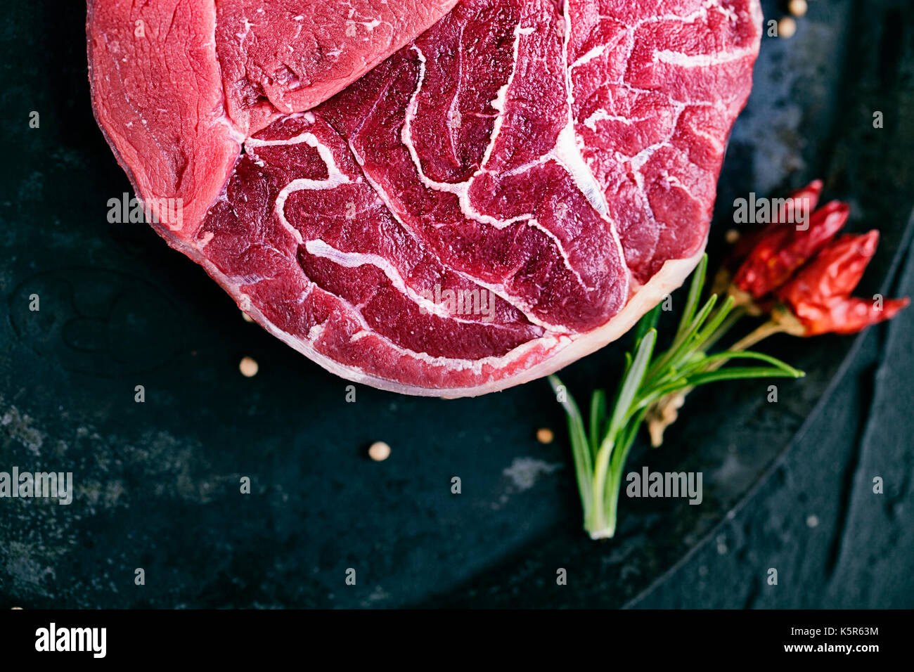 La carne. carne cruda. Filete de carne de vacuno en negro con hierbas Foto de stock