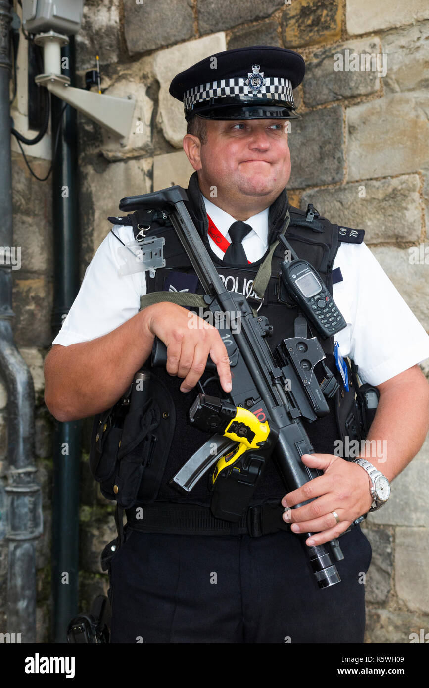 Un funcionario policial armado con un rifle y pistola de mano fuera el  castillo de Windsor, en Berkshire. En el Reino Unido. Él ha steely  determinada expresión y mirada vigilante. (90 Fotografía