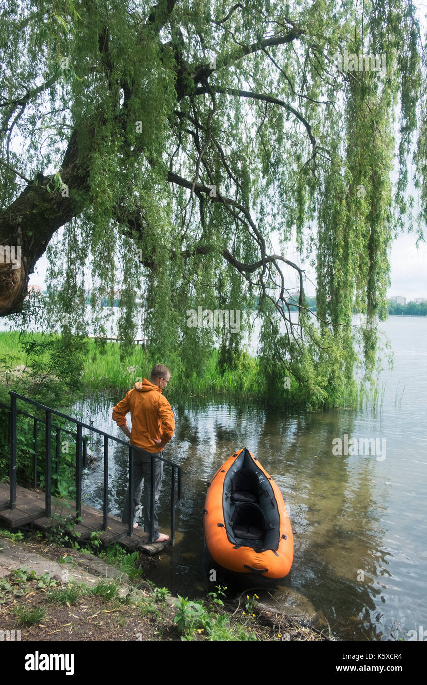 Hombre en chaqueta naranja cerca orange kayak Foto de stock