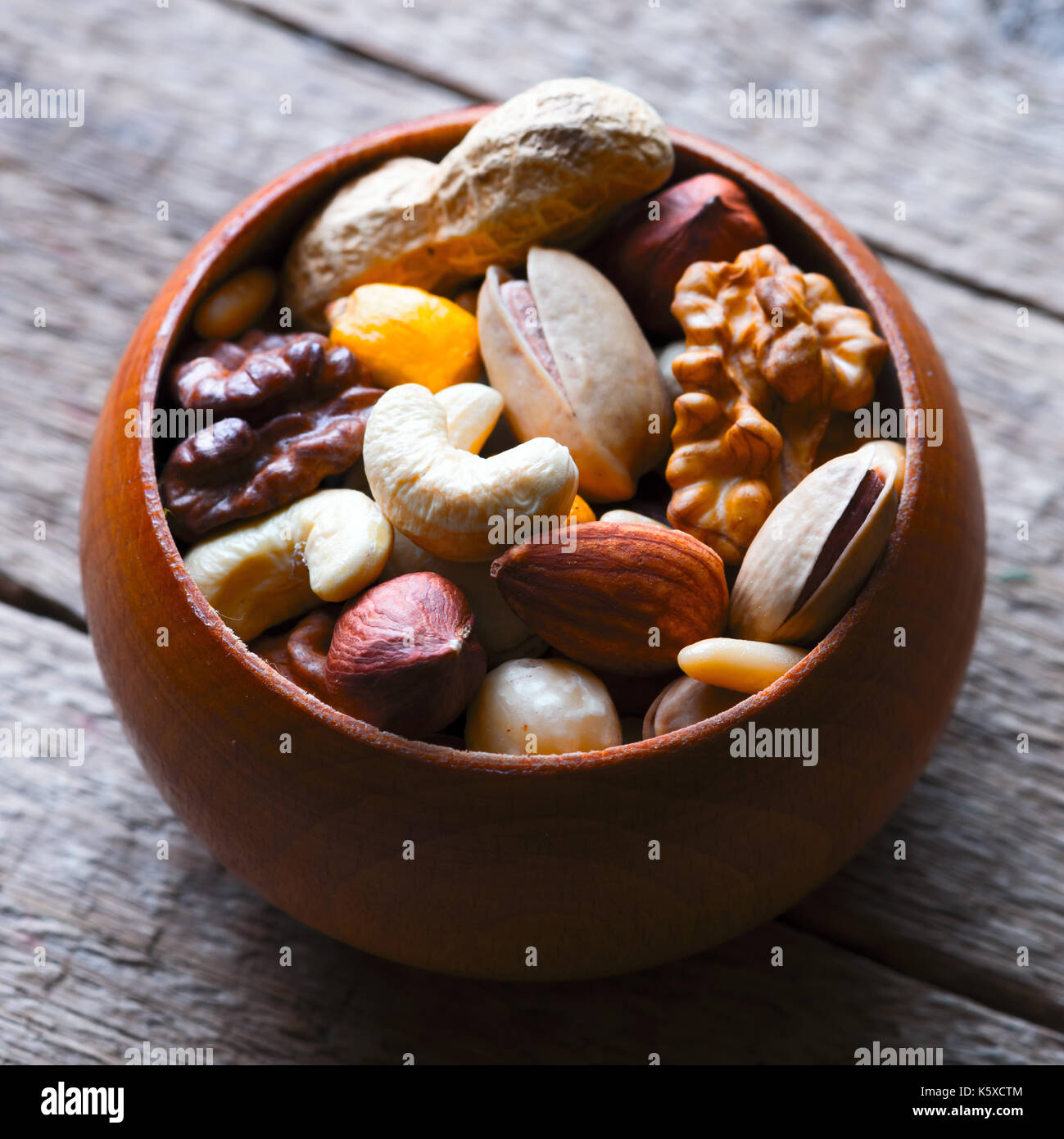 Mezcla de frutos secos en el recipiente de madera Foto de stock