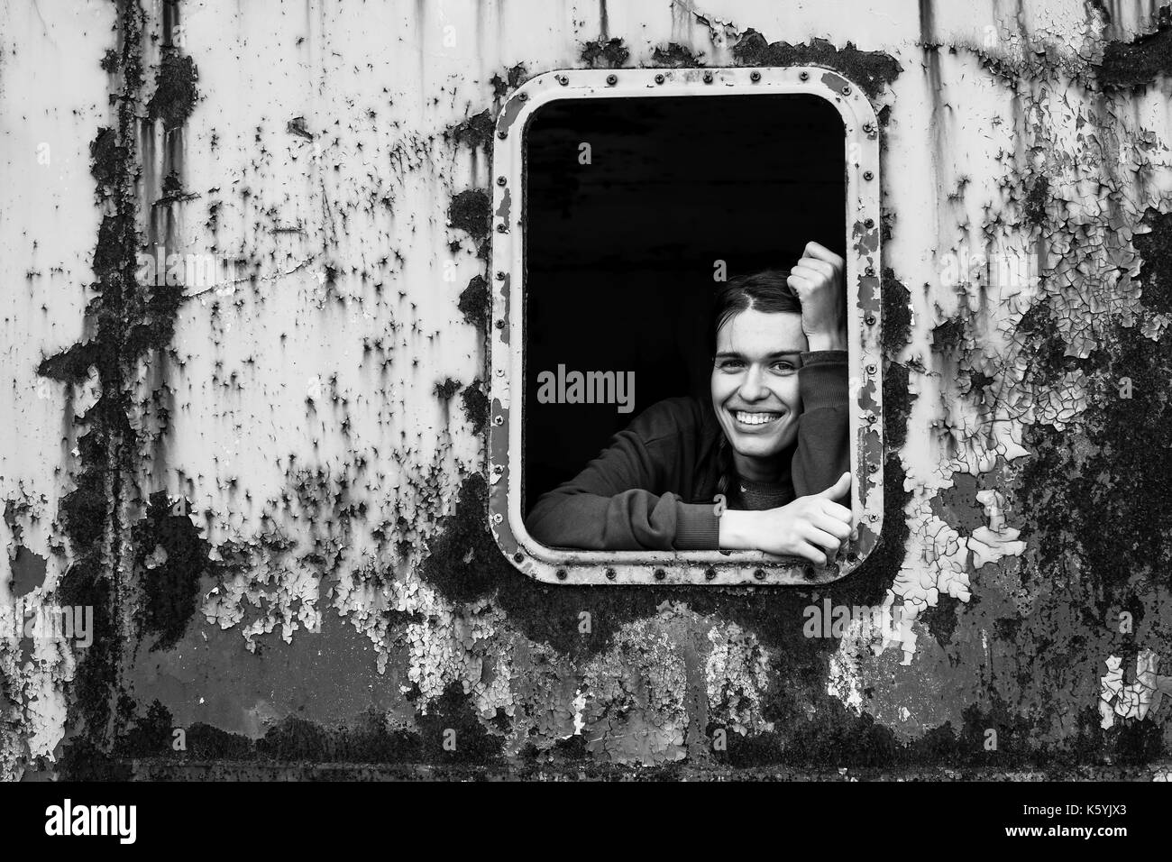 Retrato en blanco y negro de feliz joven en la ventana vintage tren. Foto de stock