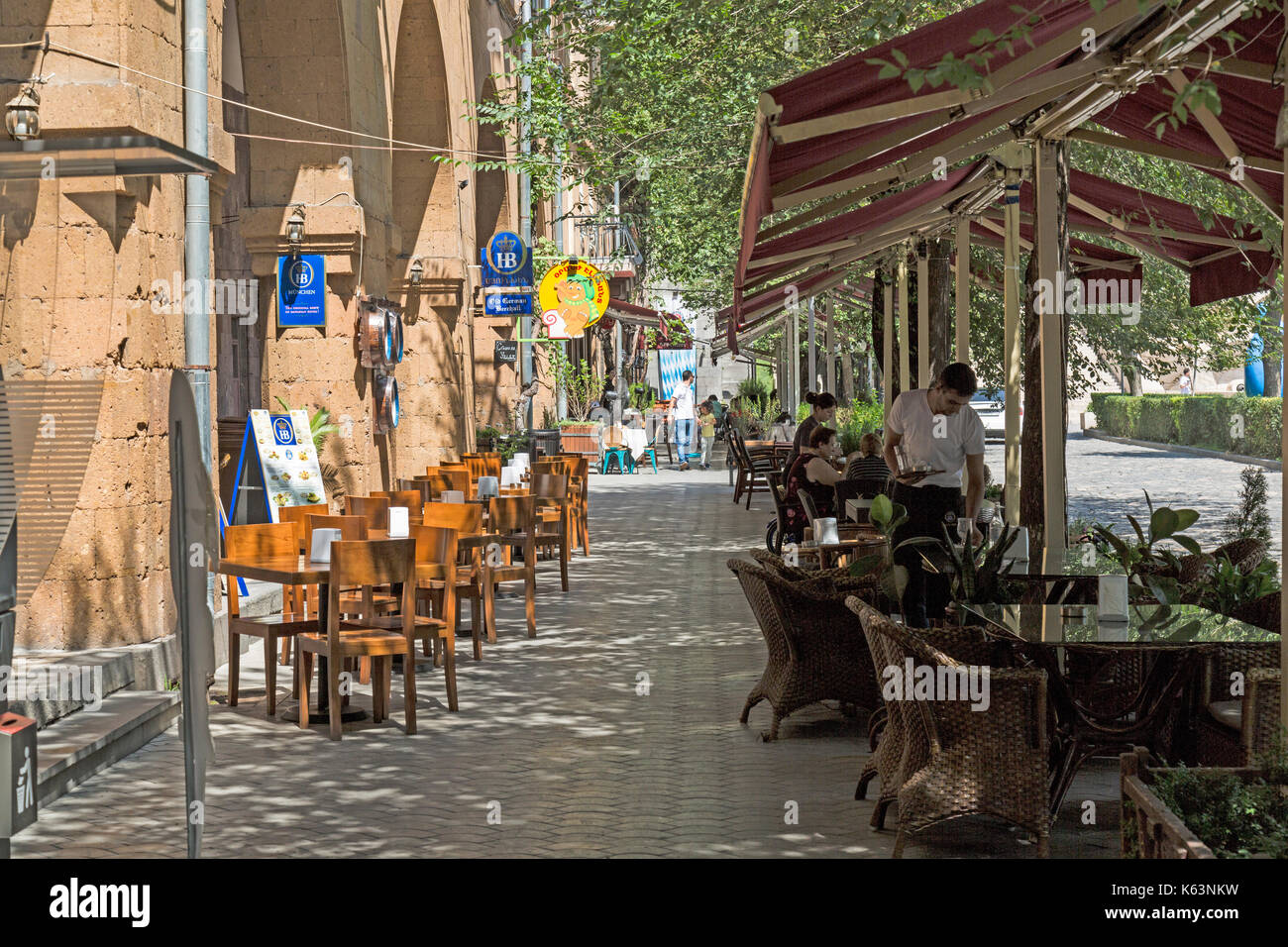 Calle en Yerevan, Armenia,con cafeterías y restaurantes. Los viejos edificios y árboles en la calle. Foto de stock