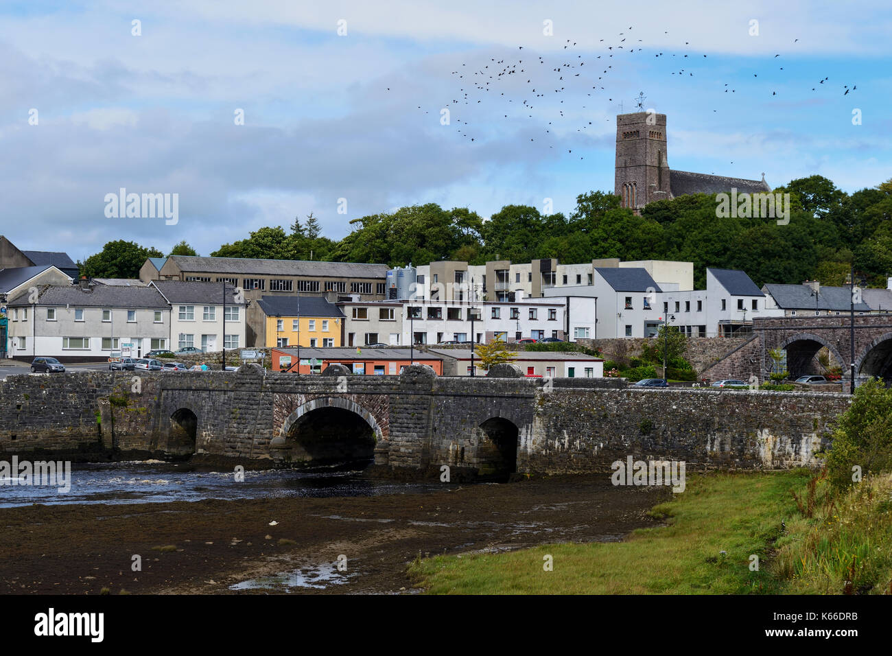 Los puentes que cruzan el río Newport con St Patrick's Church de fondo, Newport, en el condado de Mayo, República de Irlanda Foto de stock