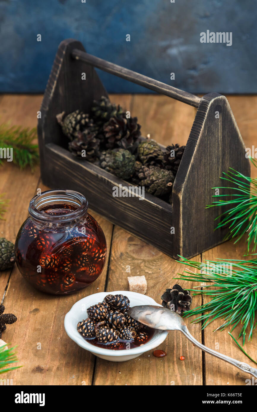 Los conos de pino mermelada en tarro con caja de madera Foto de stock