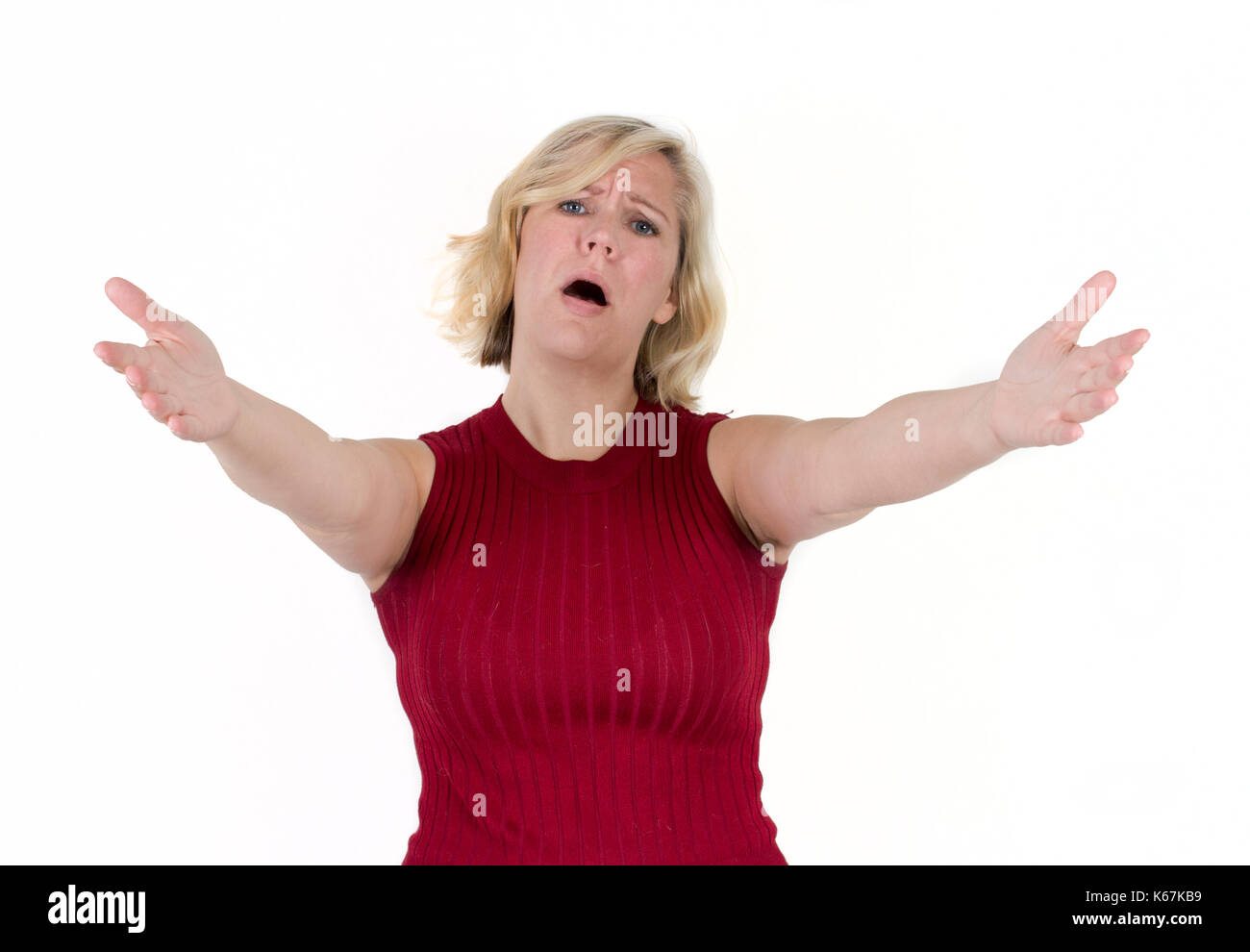 Una mujer rubia en studio fondo alcanza los brazos y las manos, con un triste o lamentándose de cara Foto de stock
