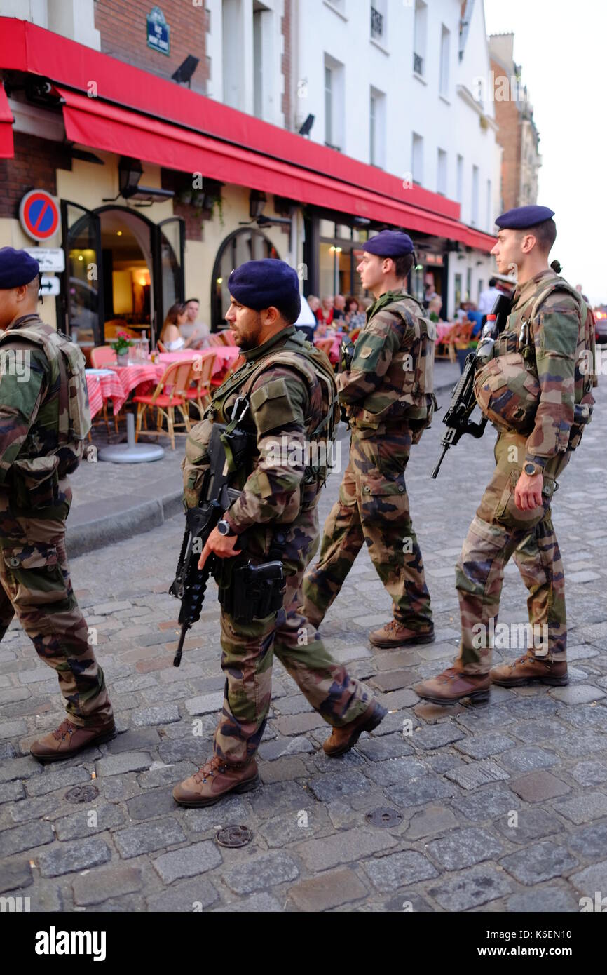Los soldados armados del ejército de Francia patrullan las calles de Montmartre en París, como resultado de la amenaza del terror levantada en la ciudad y la seguridad Foto de stock