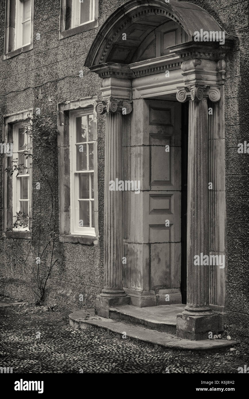Un cierre para arriba del pórtico de piedra y los pilares de un edificio georgiano en la antigua ciudad de Lancaster de Lancashire, Inglaterra, Reino Unido en blanco y negro. Foto de stock