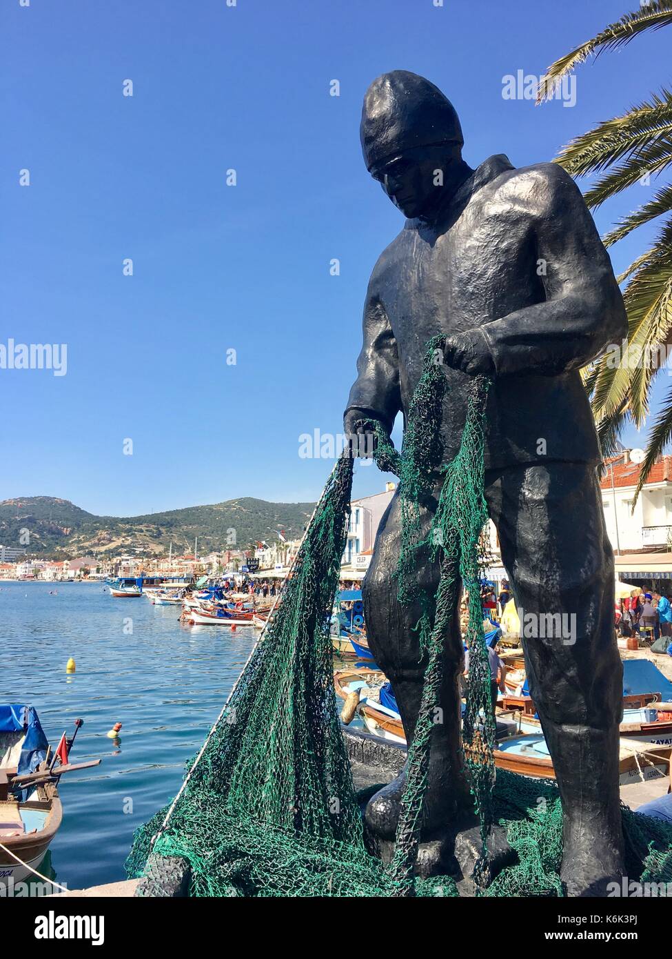 Escultura de pescadores en el centro del viejo puerto de foca izmir. La ciudad heredó su nombre(phokaia) a causa de las juntas Foto de stock