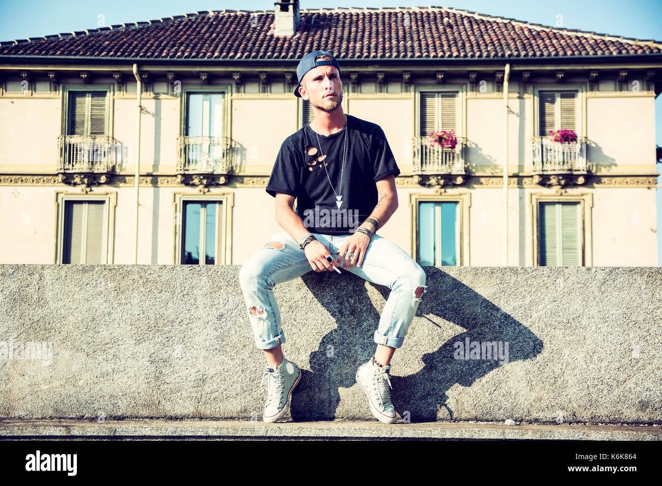 Hombre elegante wolk en la calle. El frío del invierno outfit. Gran  chaqueta con zapatillas blancas. Antecedentes Blured street. Foto modelo  profecional Fotografía de stock - Alamy