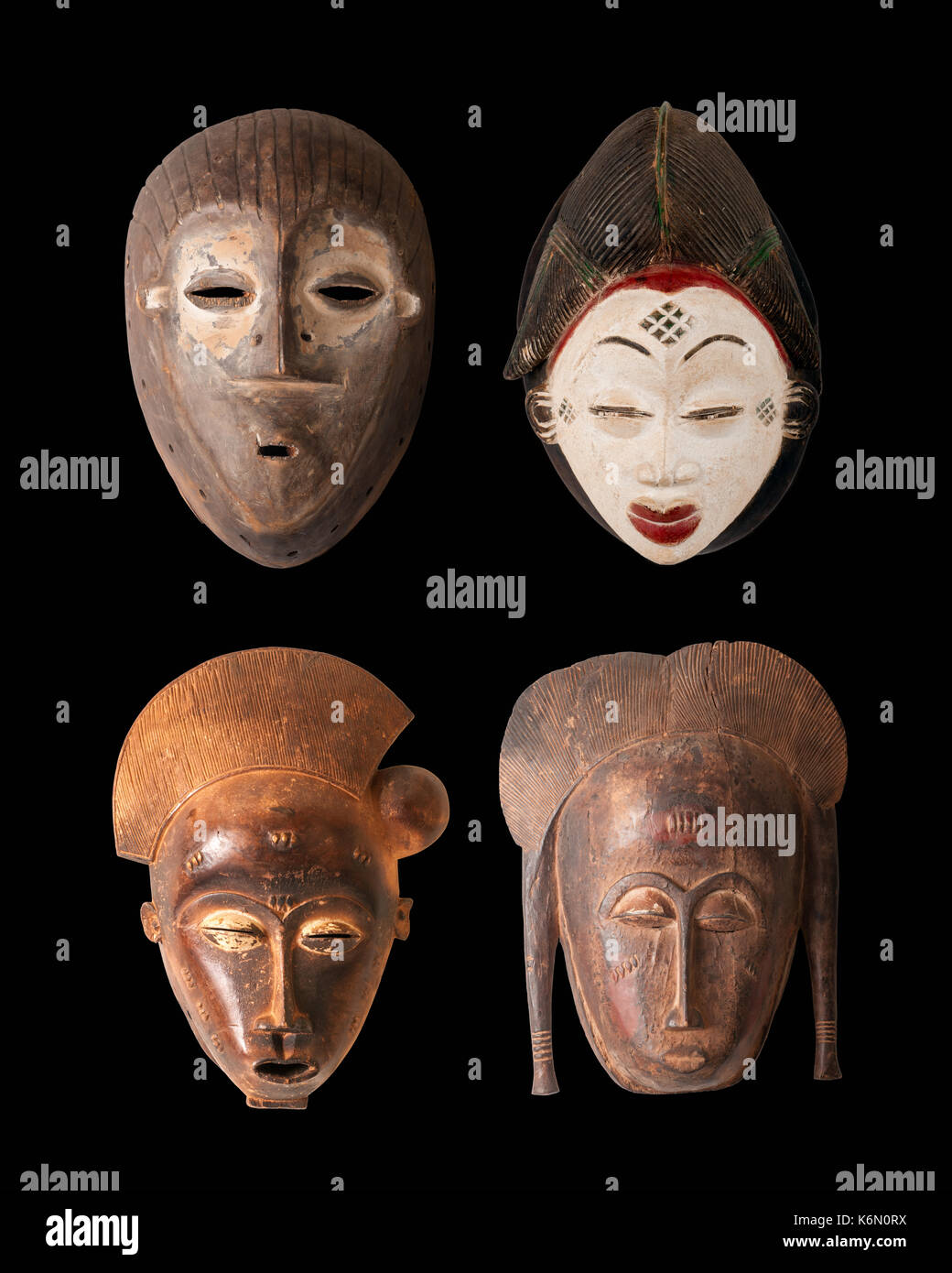 Una colección de 4 máscaras africanas talladas en madera aislado en negro  Fotografía de stock - Alamy