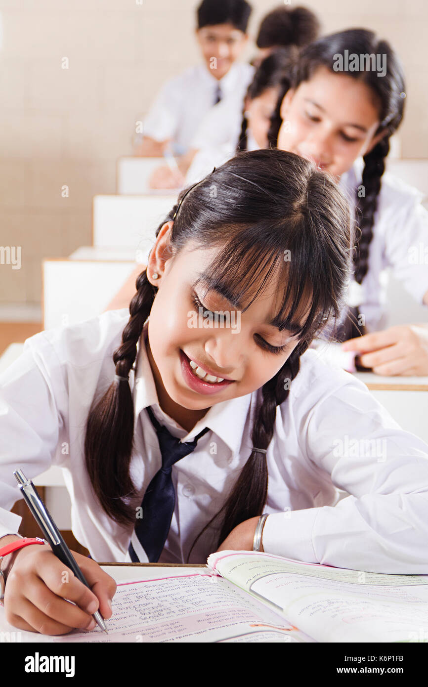 1 sonriente Indian School kid estudiante nota libro writing estudiando la educación en el aula Foto de stock
