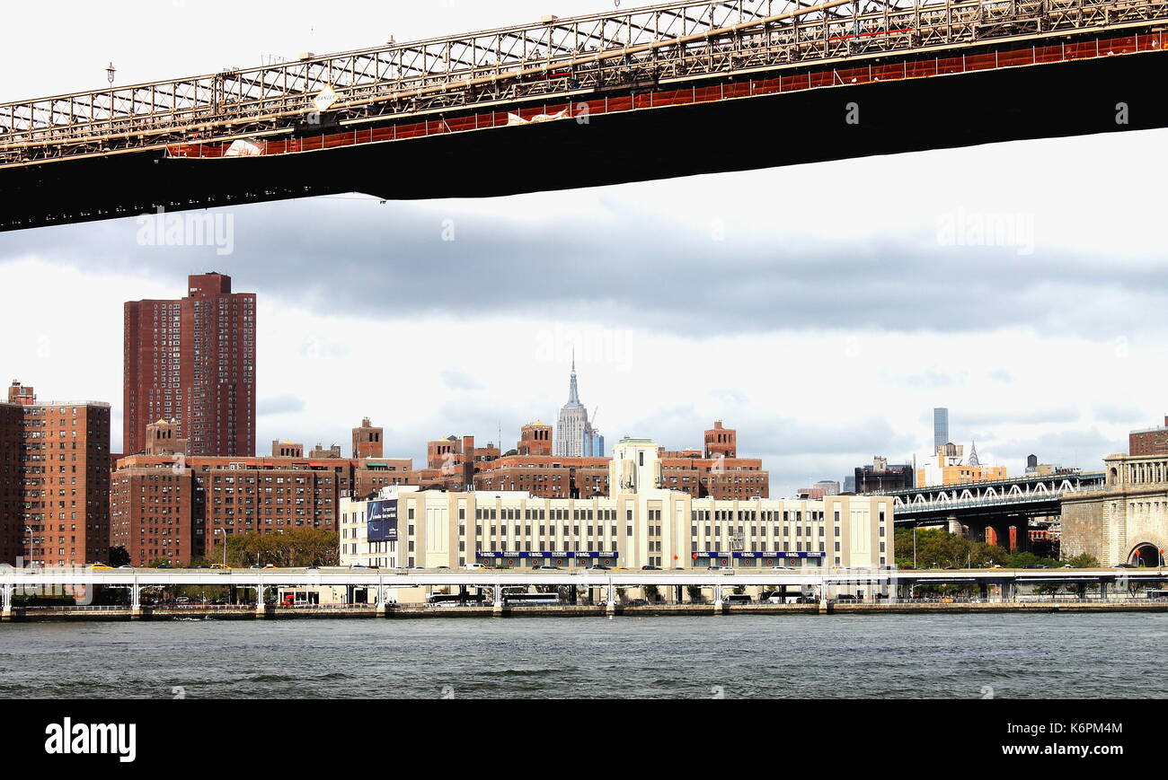 Nueva York, Estados Unidos - Septiembre 2016: Vista de revestimiento de edificios de Manhattan a lo largo del East River FDR drive desde debajo del puente de Brooklyn. Foto de stock