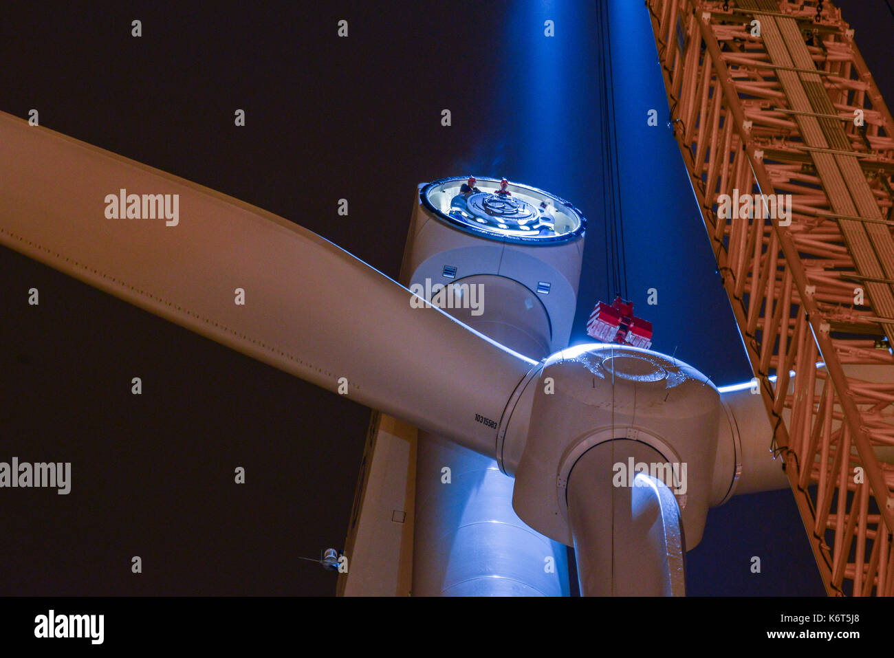 ALEMANIA Hamburgo, construcción de un nuevo aerogenerador Nordex en la planta de tratamiento de agua de Hamburgo Wasser por la noche, montaje de rotor estrella con palas con grúa, transición de energía, auténtico Foto de stock