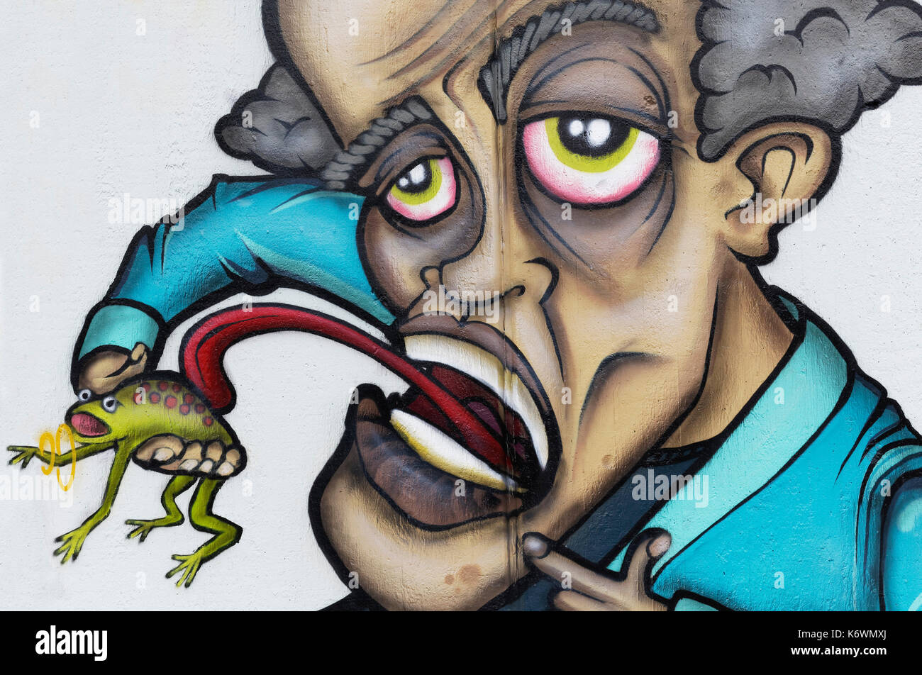 Hombre lamer sapo, graffiti, arte callejero, Düsseldorf, Renania del Norte-Westfalia, Alemania Foto de stock
