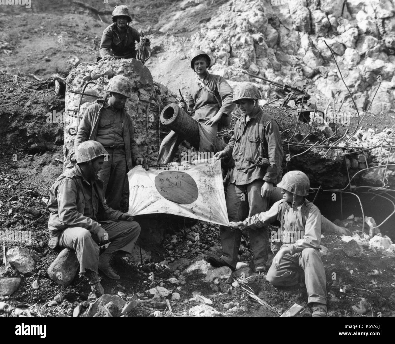 Los marines posan con una captura de bandera japonesa. Iwo Jima, 23 de febrero de 1945. Foto de stock