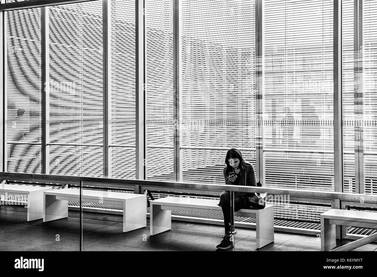 Alemania una muchacha sentada en la entrada del edificio cerrado de la topographie des terrores (topografía del terror), una exposición permanente sobre los nazis que persiguieron a los judíos, Berlín Foto de stock