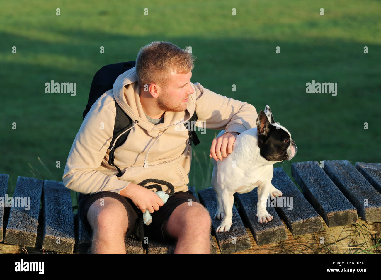 Blanco y negro Bulldog Francés en un paseo con machos jóvenes de veintitantos años Foto de stock