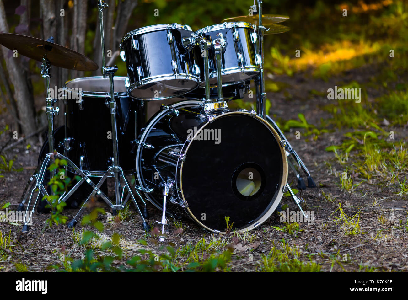 Conjunto de batería negro drum set bajo el árbol sobre la hierba Fotografía  de stock - Alamy