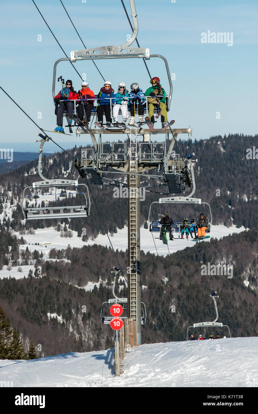 Los esquiadores sentado en una silla de la elevación de la Faucille a mont rond, jura, Francia Foto de stock