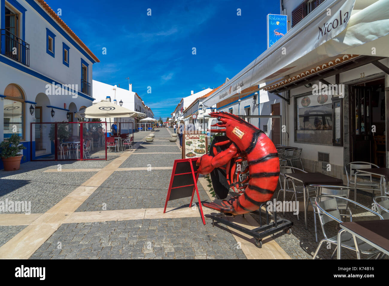 Big red lobster estatua fuera del restaurante en la calle adoquinada Rua Vasco da Gama en Porto Covo Portugal Foto de stock