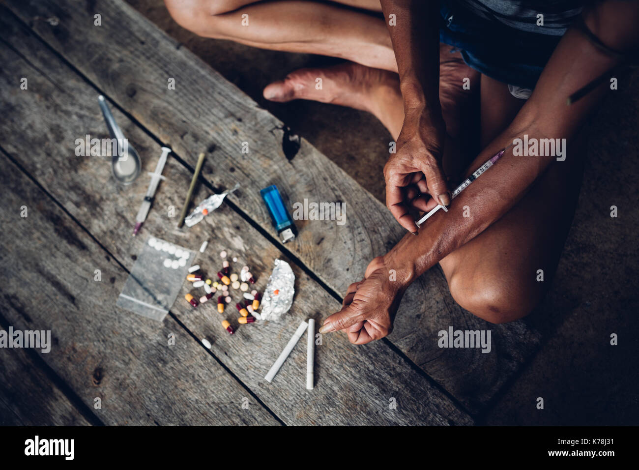 Drogadicto joven con jeringa en acción, el concepto del uso indebido de drogas. Foto de stock