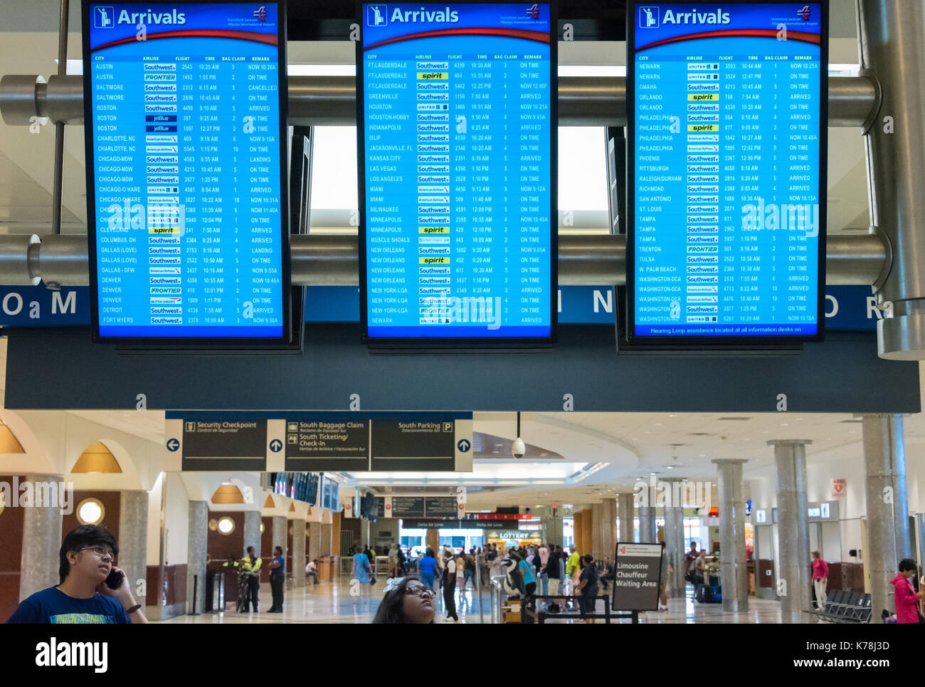 Las personas controlar la llegada del vuelo display boards en Hartsfield Jackson de Atlanta, el aeropuerto internacional de Atlanta, Georgia. (Ee.Uu.) Foto de stock