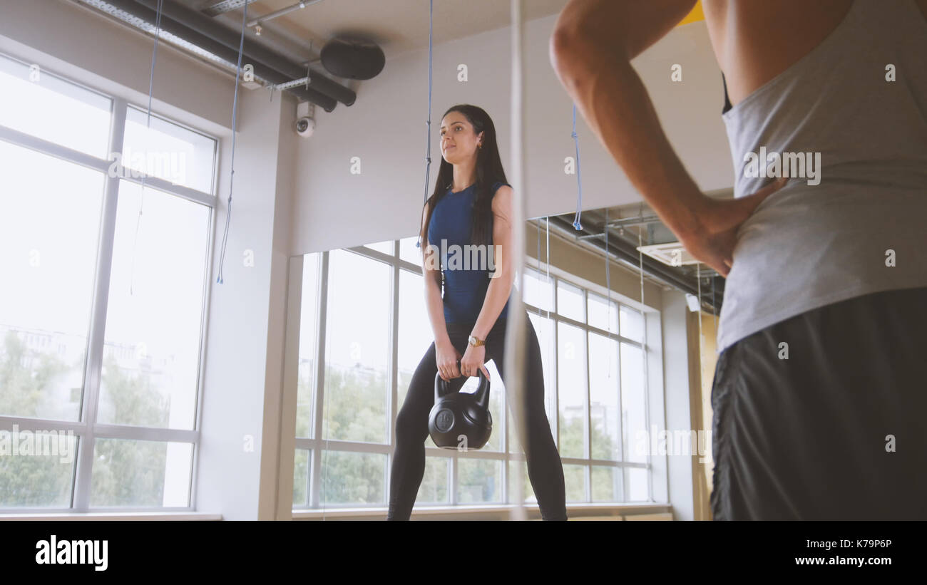 Mujer trabajando fuera haciendo sentadillas con peso en el gimnasio. Foto de stock