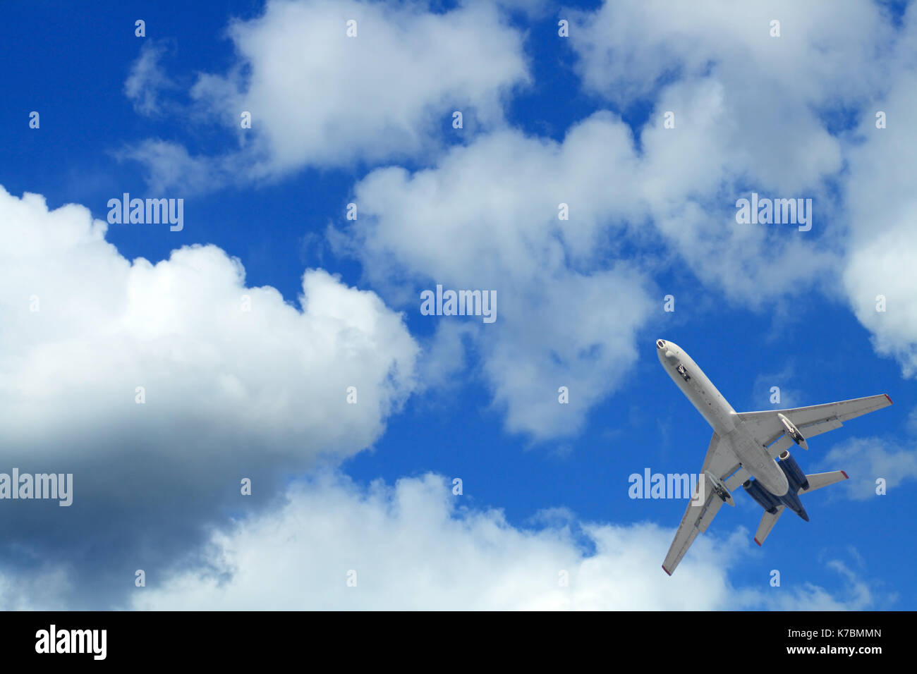 Avión de pasajeros que volaban en el cielo azul con nubes Foto de stock