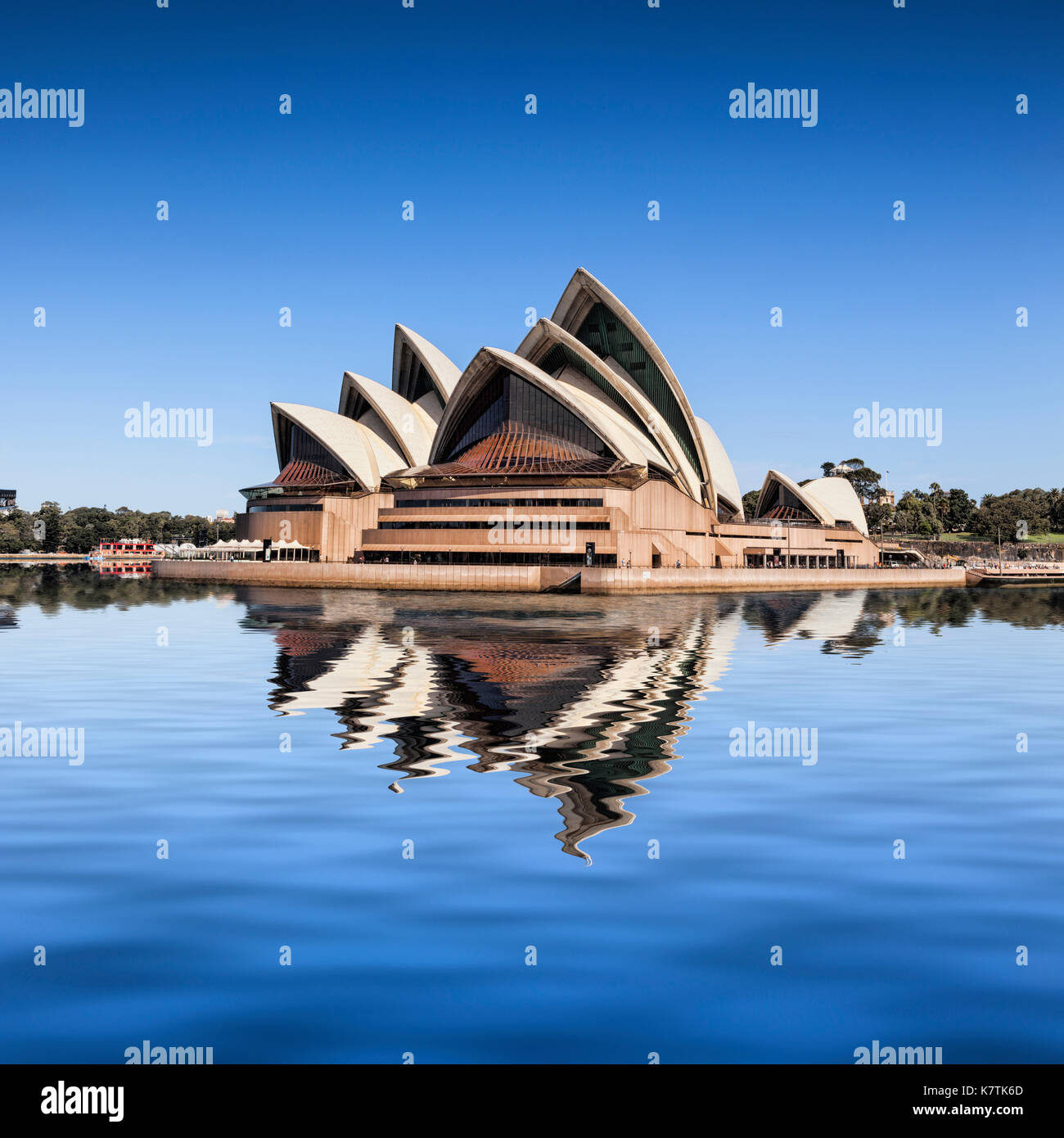 Sydney Opera House,visto desde el paso de un barco, que se refleja en la bahía de Sydney. Foto de stock