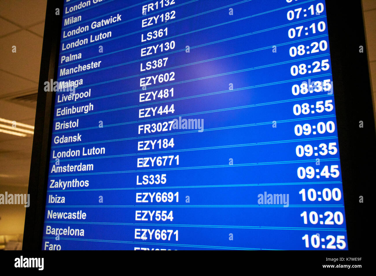 Pantalla que muestra información de vuelos del aeropuerto destinos códigos de línea aérea de bajo coste y los tiempos de vuelo Foto de stock