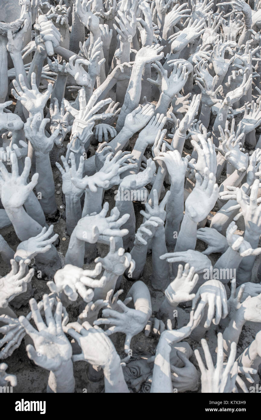 Alcanzar esculturas de mano que simbolizan el deseo desenfrenado en el puente del "ciclo del renacimiento" en Wat Rong Khun (Templo Blanco). Chiang Rai, Tailandia Foto de stock