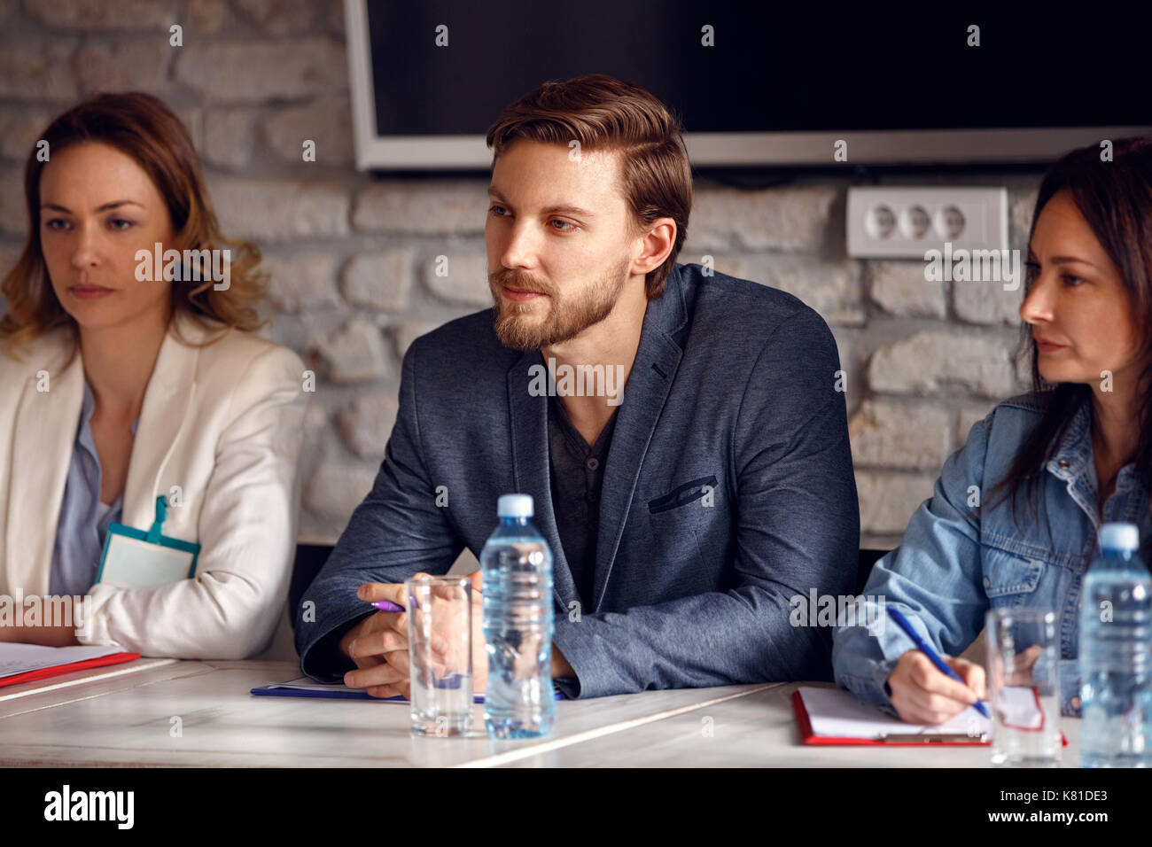 Hombre serio con dos compañeras en la comisión de empleo en la empresa Foto de stock