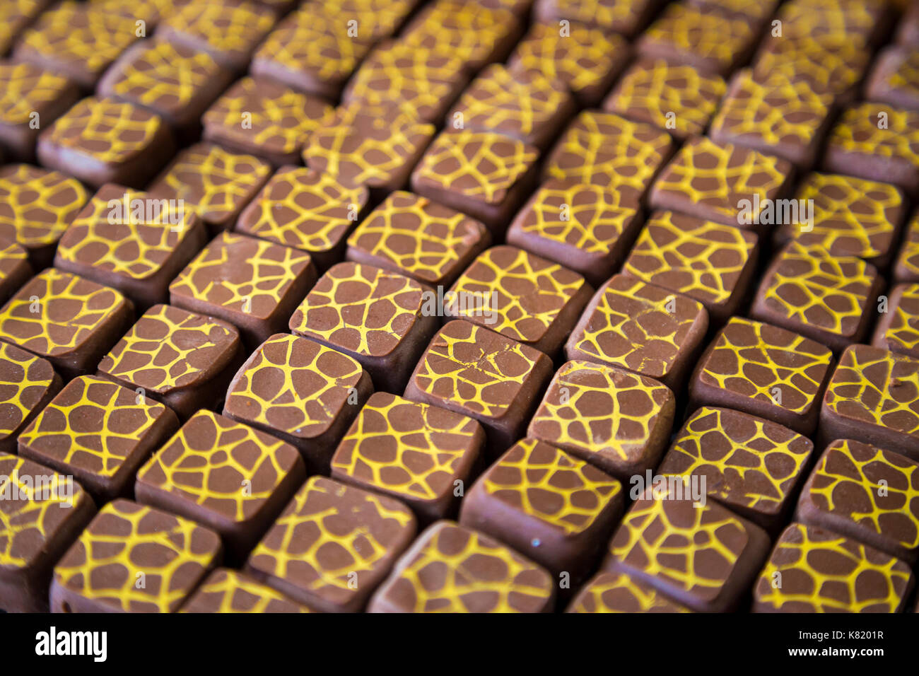 Pralines estampadas en exhibición en tazones de madera oscura (azúcares Cacao House, Londres, Reino Unido) Foto de stock