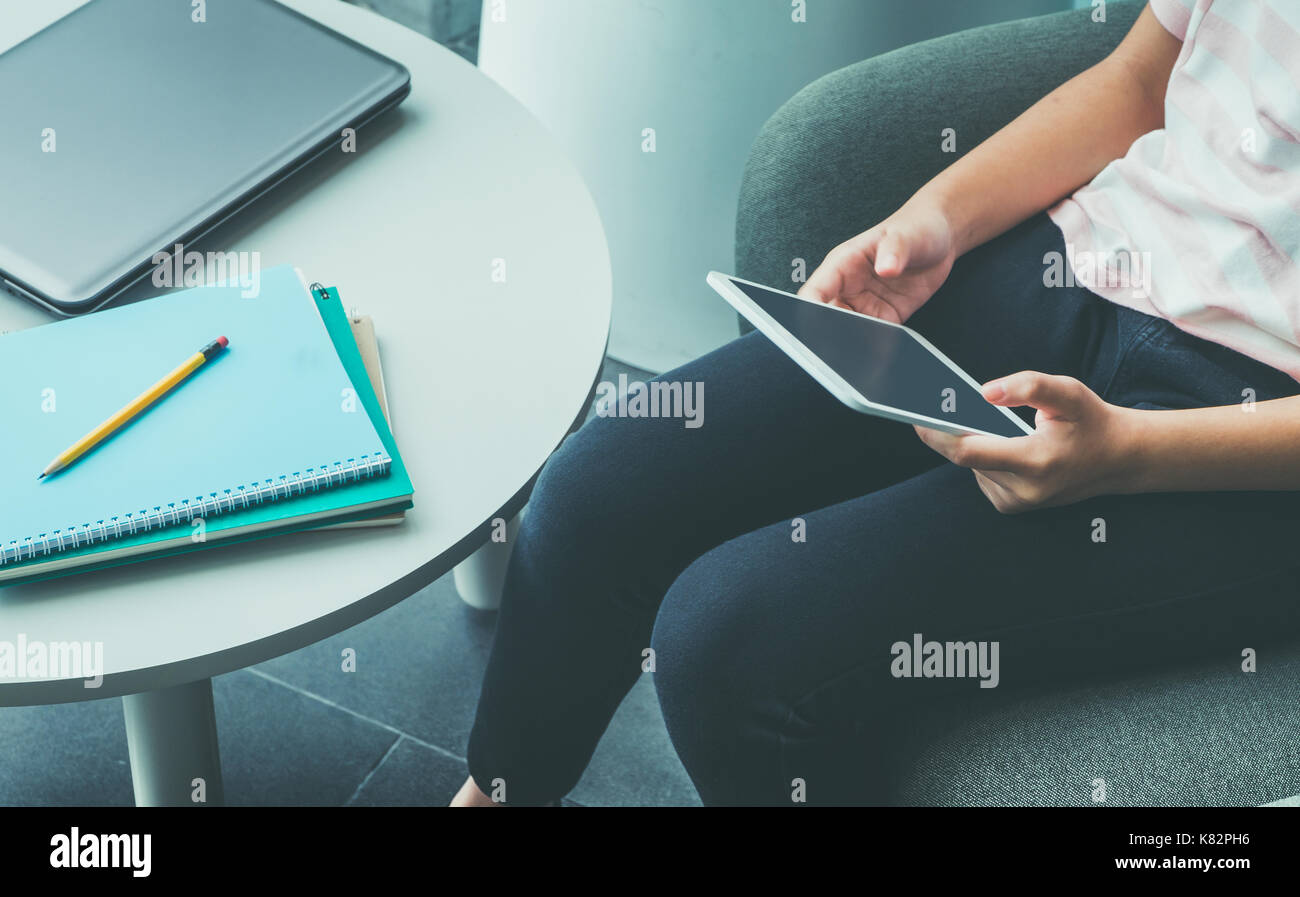Cerrar la mano de chica sentada y toque en blanco la pantalla del tablet PC con bloc de notas y lápiz sobre tabla en el campus, la educación en línea (e-learning) conc Foto de stock