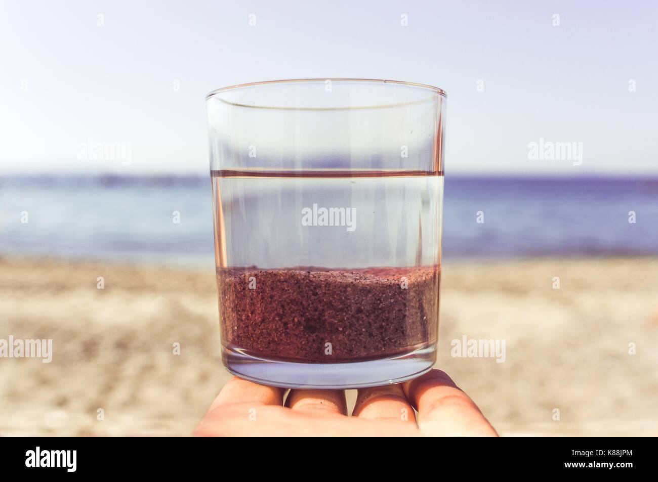 Un vaso conteniendo tres elementos (aire, agua y arena ...