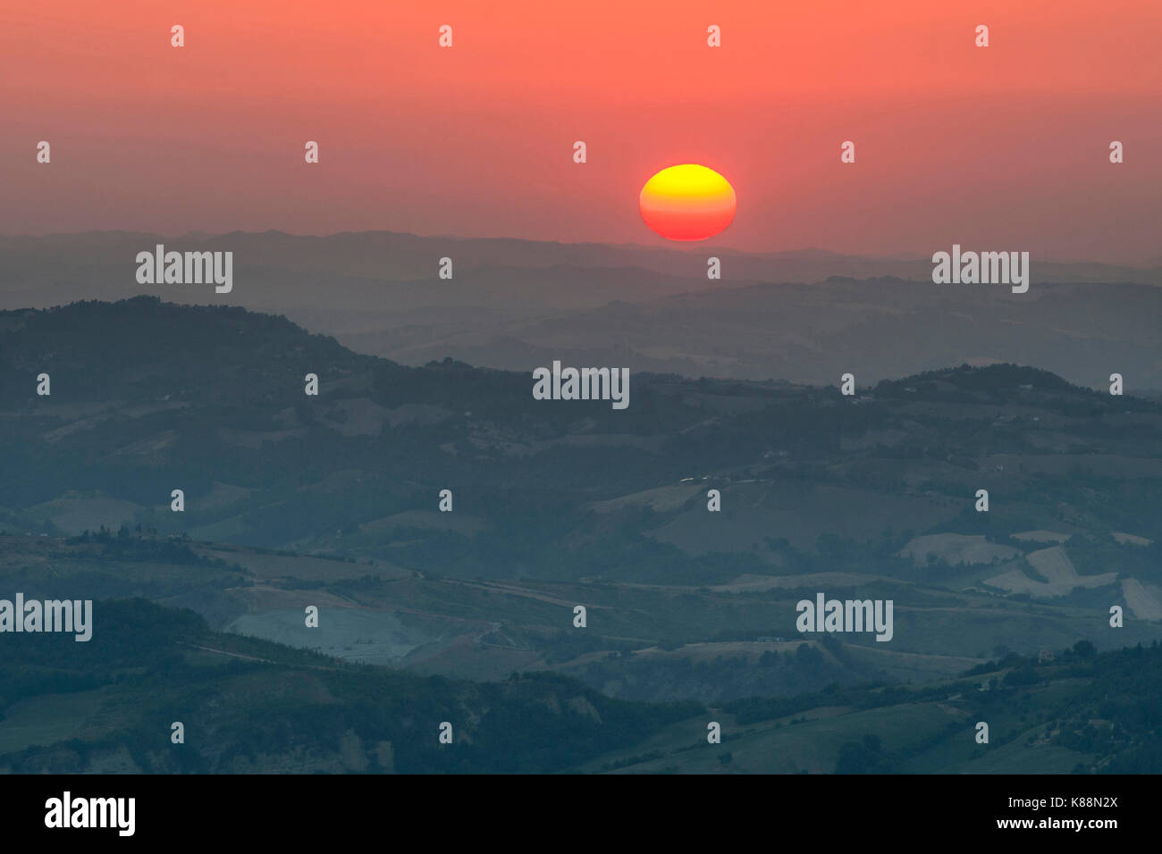 Puesta de sol sobre las montañas y el campo de San Marino. Foto de stock