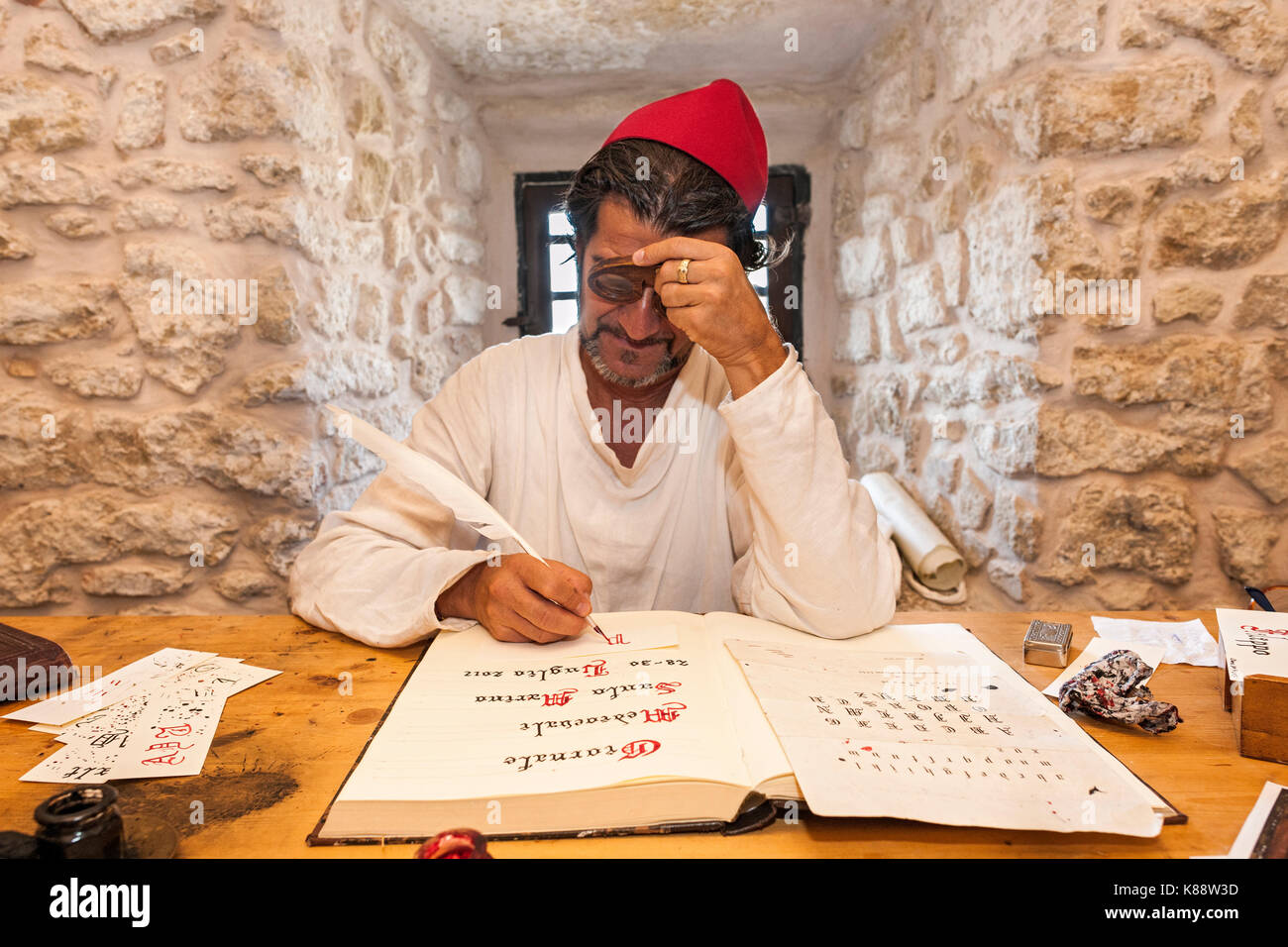 Hombre vestido y actuando como un escribano durante los días del Festival Medieval anual celebrada en el casco antiguo de la ciudad de San Marino en la República de San Marino. Foto de stock
