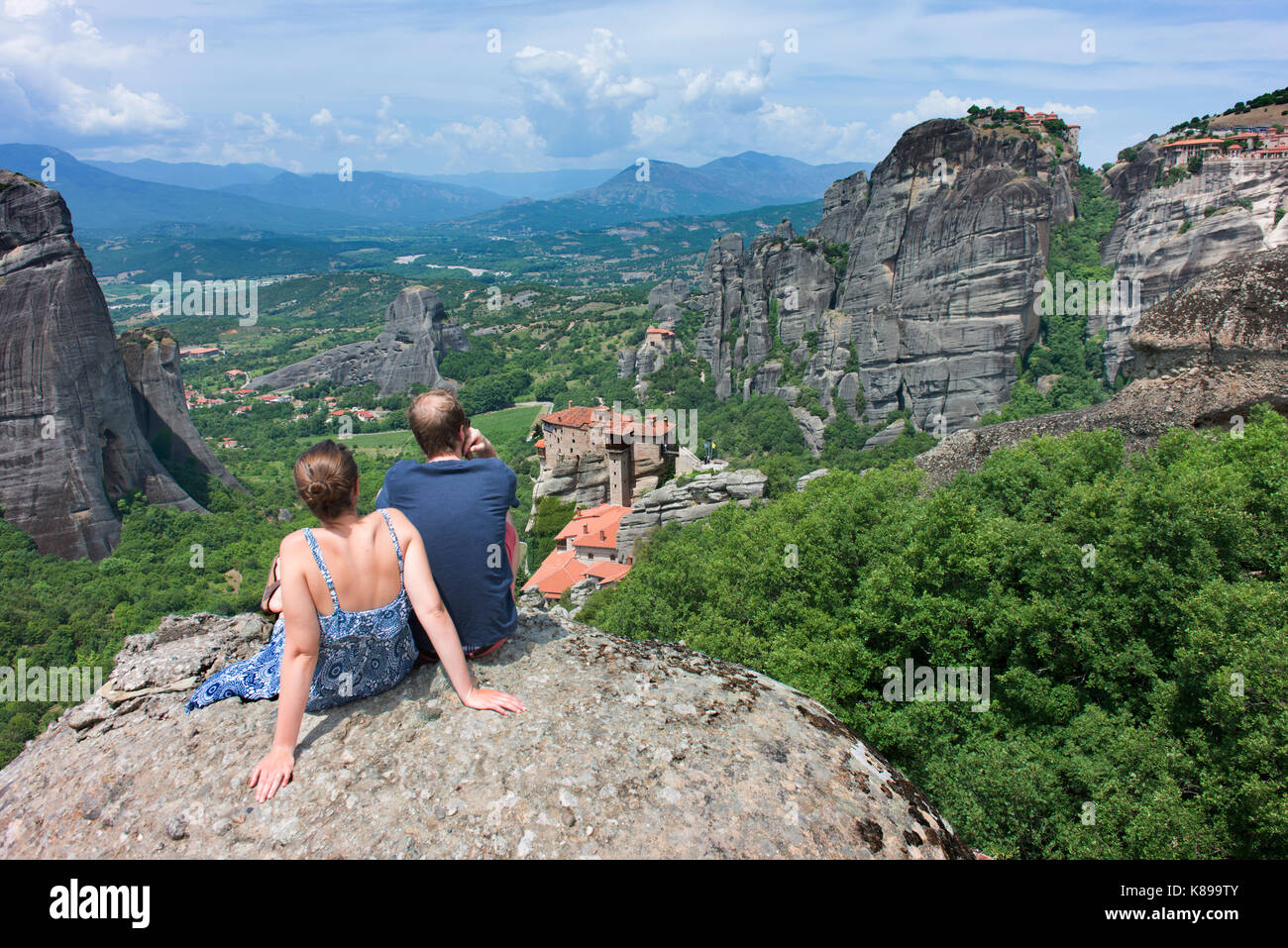 Una joven pareja admire la vista de algunos de los monasterios de Meteora. Foto de stock