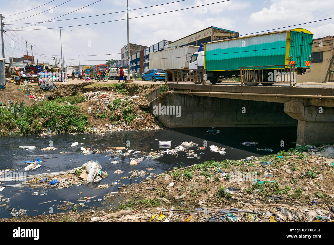 Enterprise road bridge cruza el río Ngong que está contaminada con basura, desechos plásticos y basura, Nairobi, Kenia Foto de stock