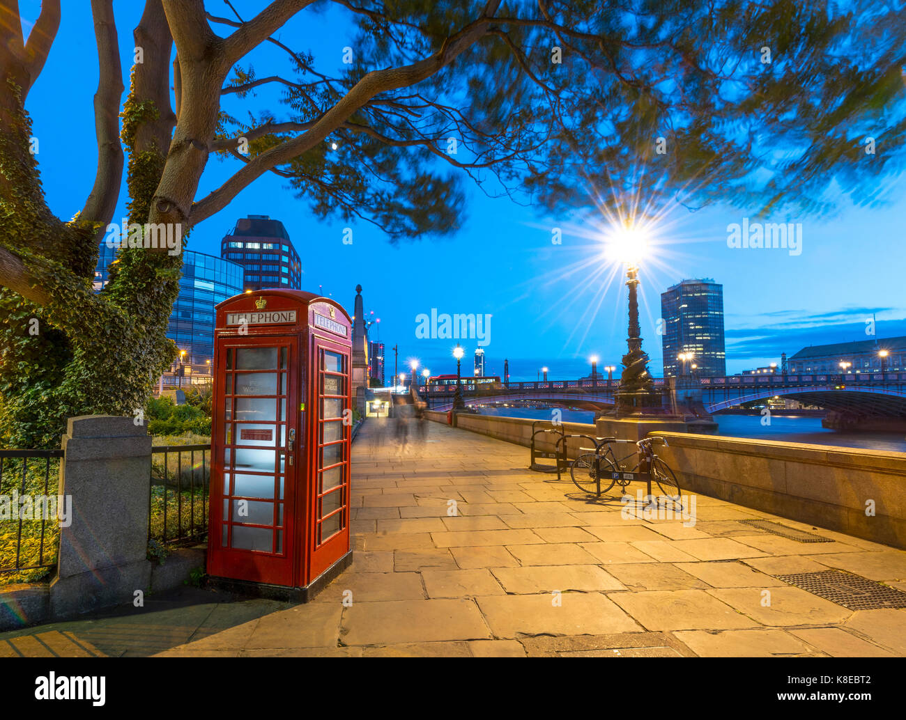 Cuadro teléfono rojo típico, paseo peatonal junto al Támesis, Londres, Inglaterra, Gran Bretaña Foto de stock