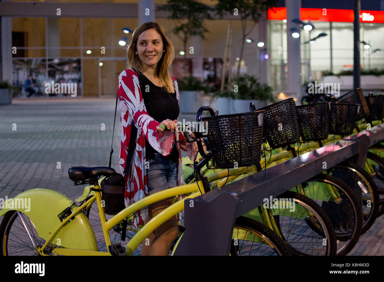 Mujer mirando lejos al alquilar bicicletas en ciudad Foto de stock