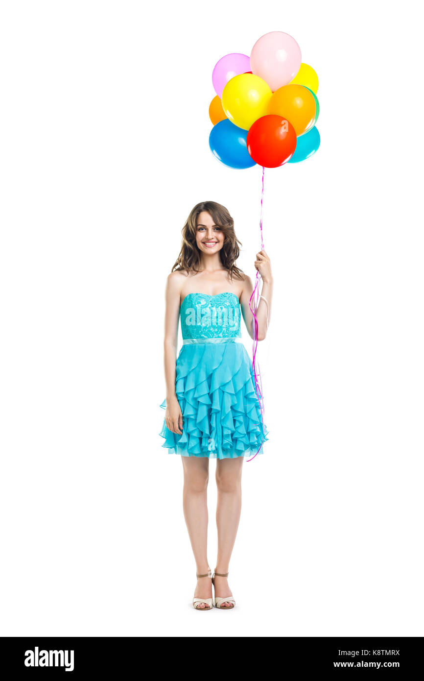 Feliz hermosa mujer de vestido azul sosteniendo globos de colores aislado sobre fondo blanco retrato de longitud completa. Foto de stock