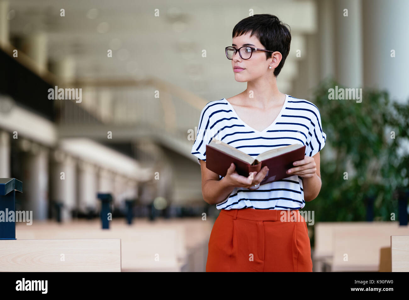 Retrato de joven estudiante en la biblioteca Foto de stock