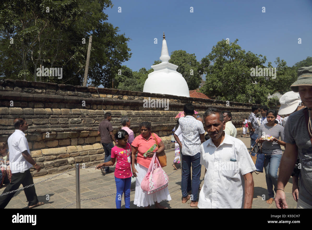 Kandy, Sri Lanka, Templo de la Reliquia del Diente Sagrado de los peregrinos y los turistas que caminan pasado Dagoba Foto de stock