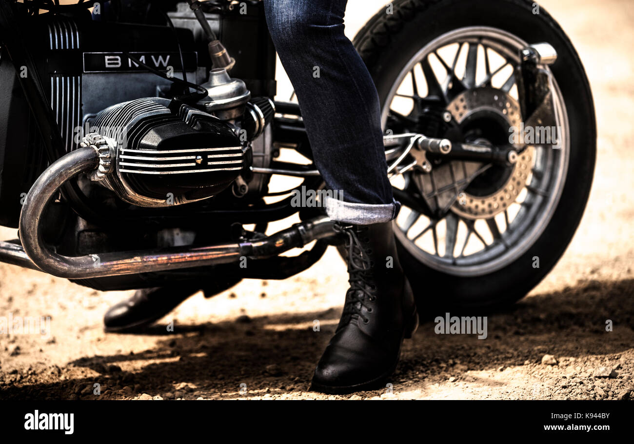 Bajo la sección Vista de hombre vestido con pantalones vaqueros y las botas  de cuero negro sentado en cafe racer moto Fotografía de stock - Alamy