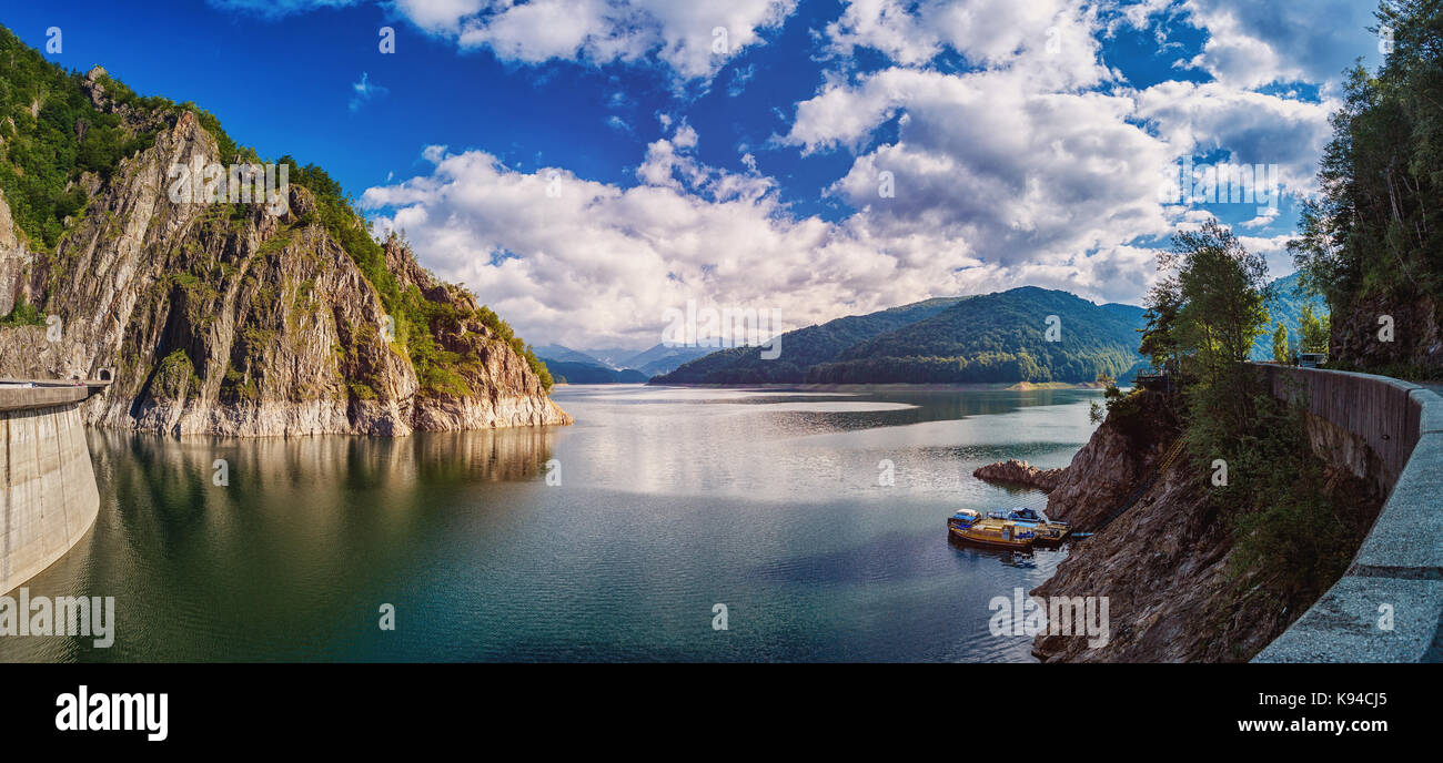 Panorama de un lago de montaña cerca de la presa. hermoso cielo azul con nubes Foto de stock