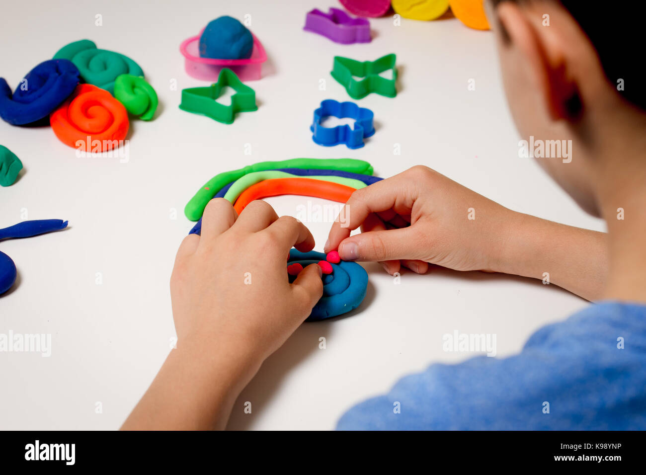 Boy jugar y crear a partir de la plastilina o arcilla de modelado en el  cuadro blanco Fotografía de stock - Alamy
