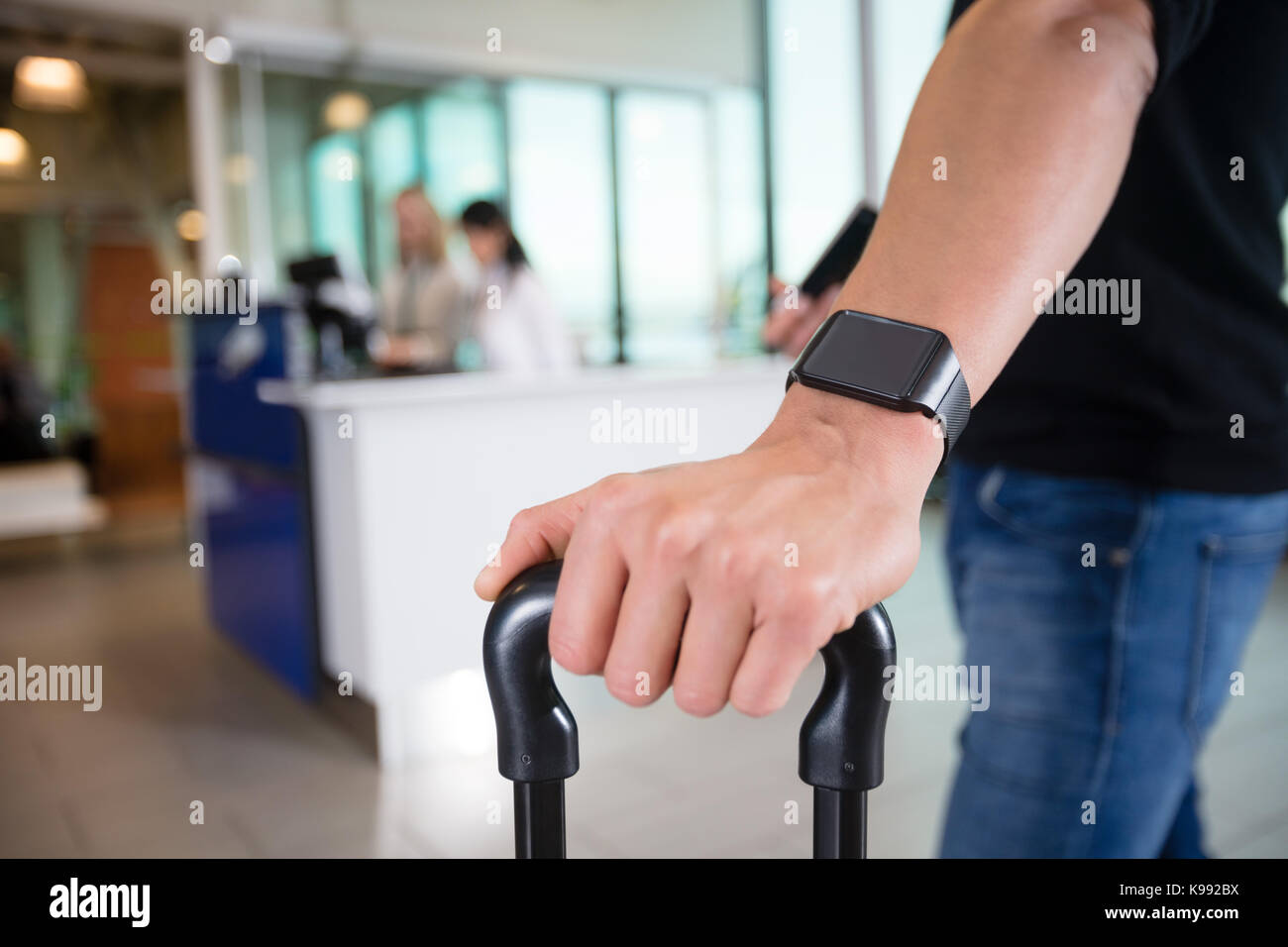 Hombres de pasajeros usando Smart Watch en el aeropuerto Foto de stock