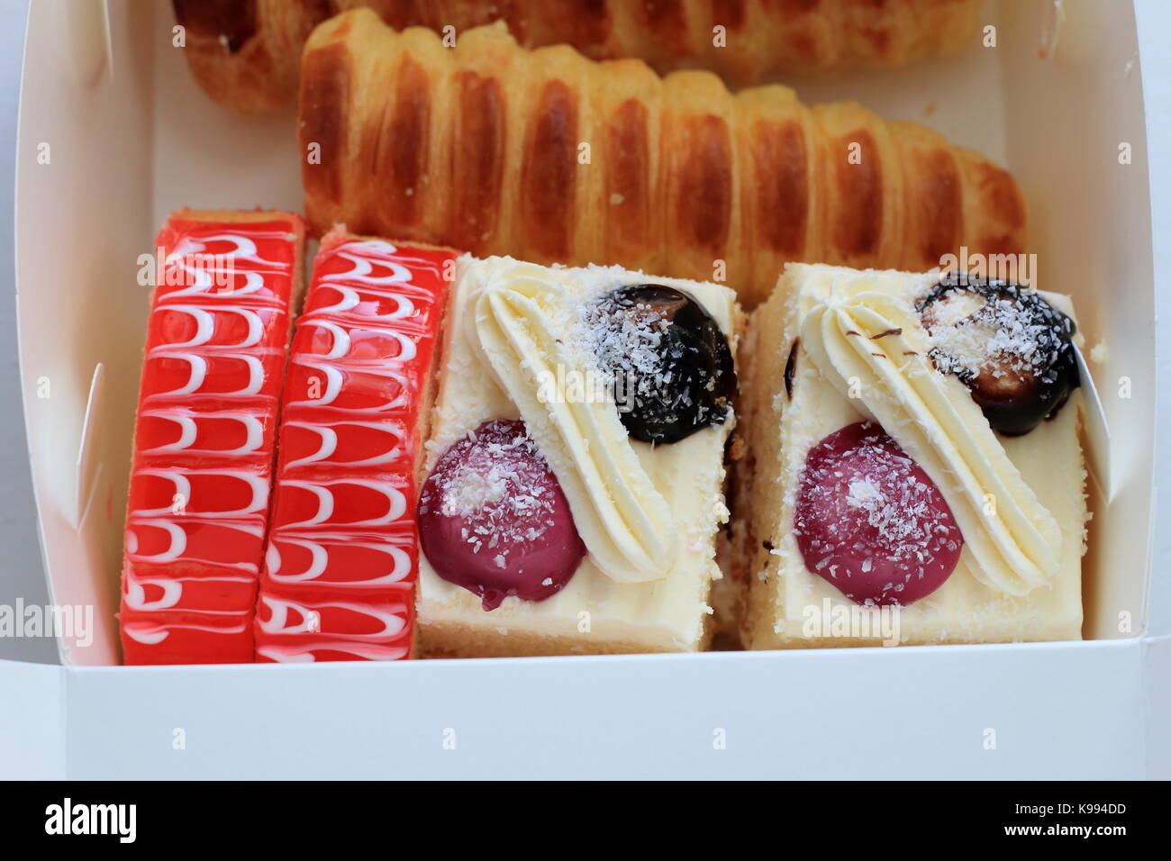 Una caja de variedades mixtas de pasteles y postres. Foto de stock